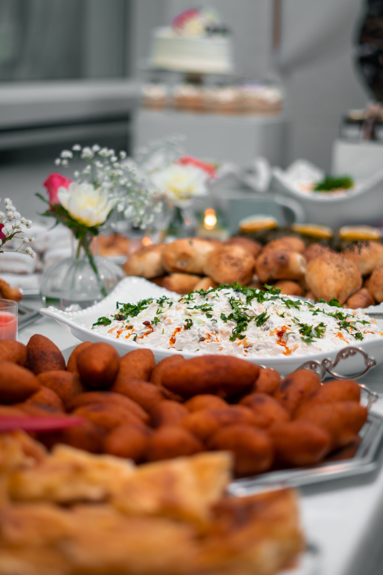 Platters of freshly prepared finger food and dips on a white table